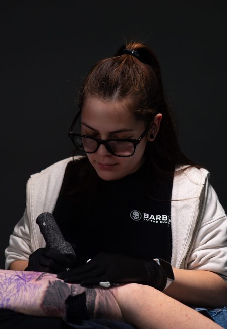 Betza Osuna tatuadora especializada en realismo realizando tatuaje a color en su estudio en Madrid